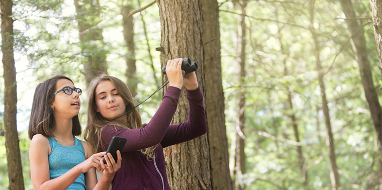 Girls using smartphone to study nature