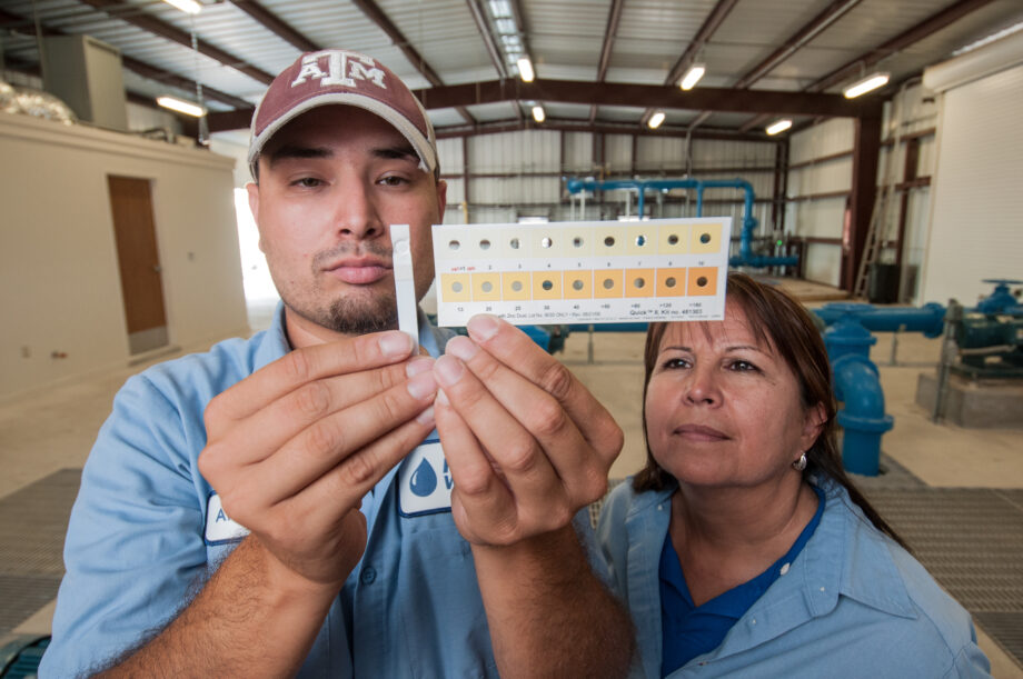 Freer Water Control and Improvement District Manager Diana Adame, right, and plant worker Anthony Arredondo, compare a test strip to a calibration chart to show water from Freer, Texas has less than one part per billon of arsenic