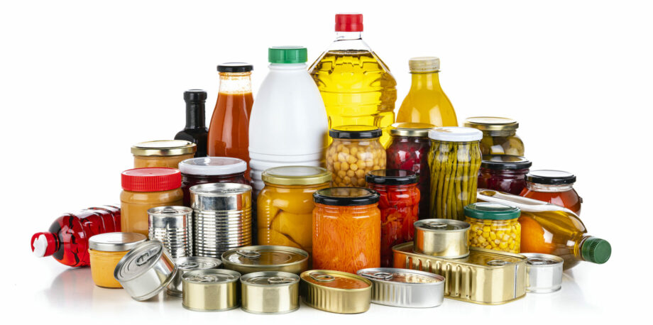 Non-perishable food: front view of a large group of multicolored unbranded canned goods, conserves, sauces and oils isolated on white background.