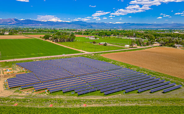 Photo of solar panels over an agricultural field at Jack's Solar Garden