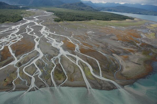 Aerial photograph. Magnificent braided river delta with red and green flora showing at low tide. Alaska, Lower Cook Inlet, Kachemak Bay.