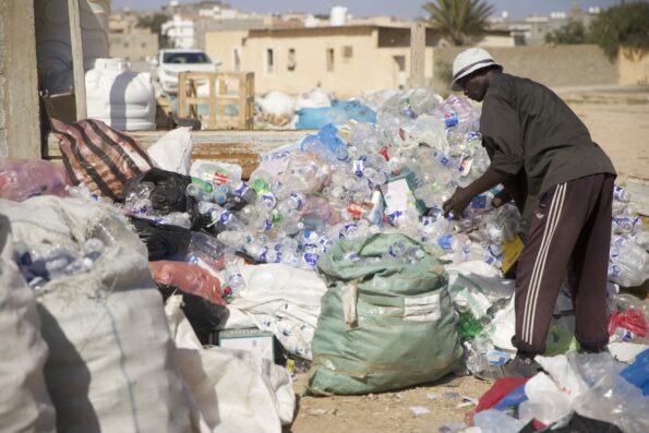 Photo of man sorting plastic for recycling