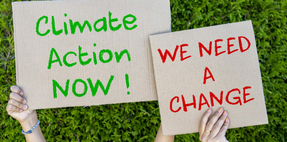 Activists with Save the planet and We need a change placard at climate change prostest