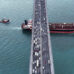 From Above,the Bosphorus Bridge in Istanbul Spans the Shimmering Waters of the Marmara Sea. Vehicles Traverse the Bridge While a Barge Glides Beneath,Capturing the Dynamic Movement of the City against the Tranquil Seascape Backdrop